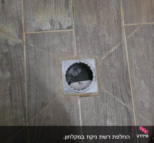 תמונה של רצפה עם חור עגול, כלי עבודה בצד